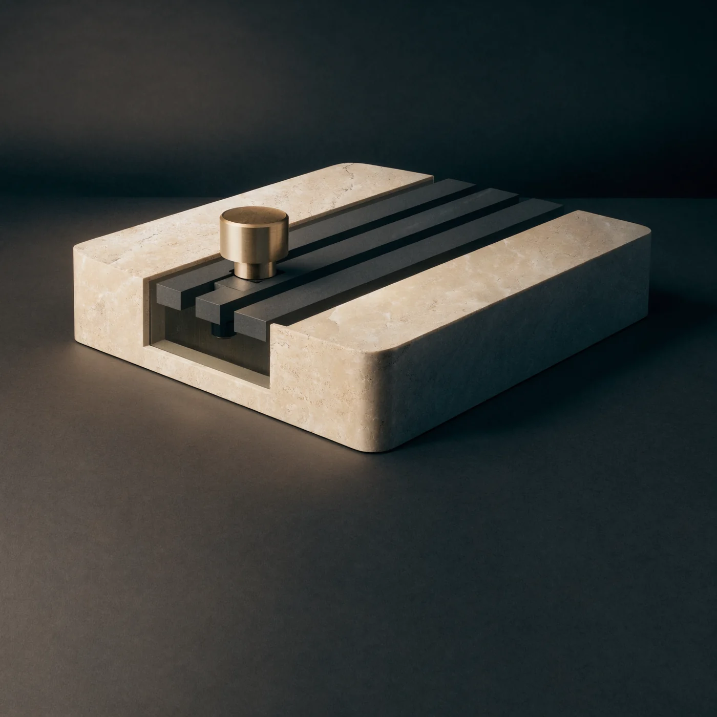 A brushed-metal control sits on parallel graphite rails inset into stone.